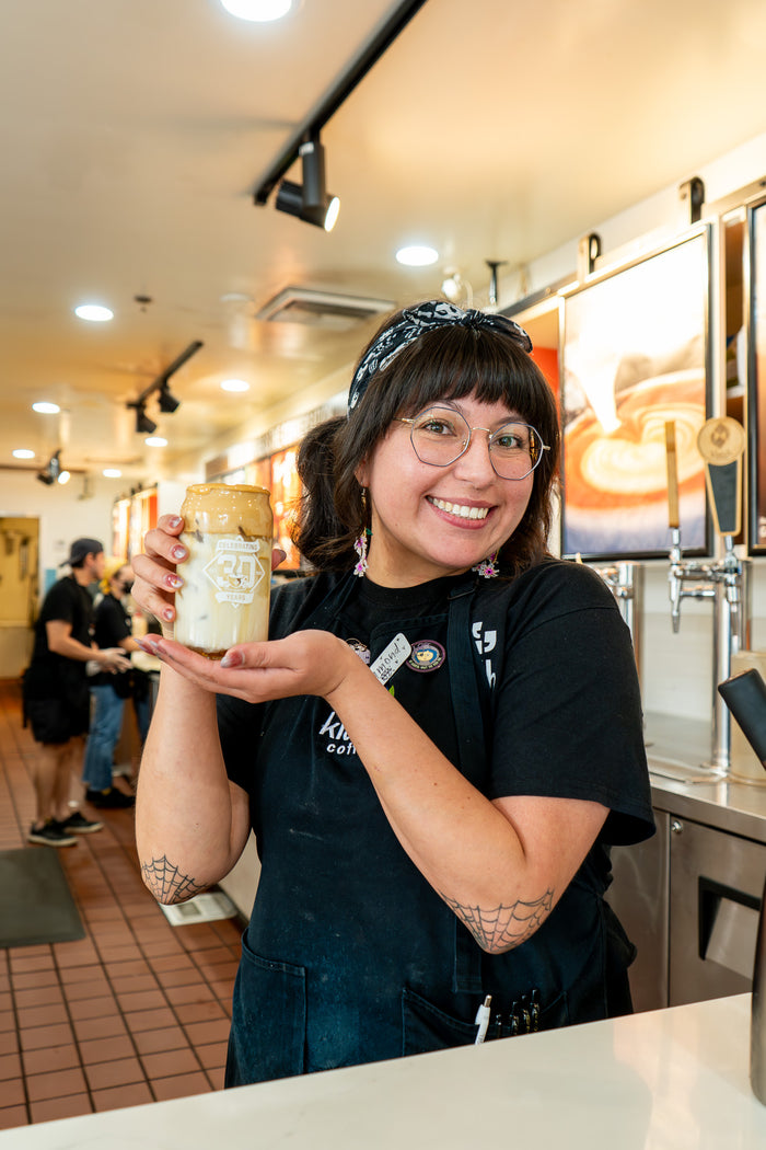 Woman with a drink at Klatch Coffee's San Dimas, CA location