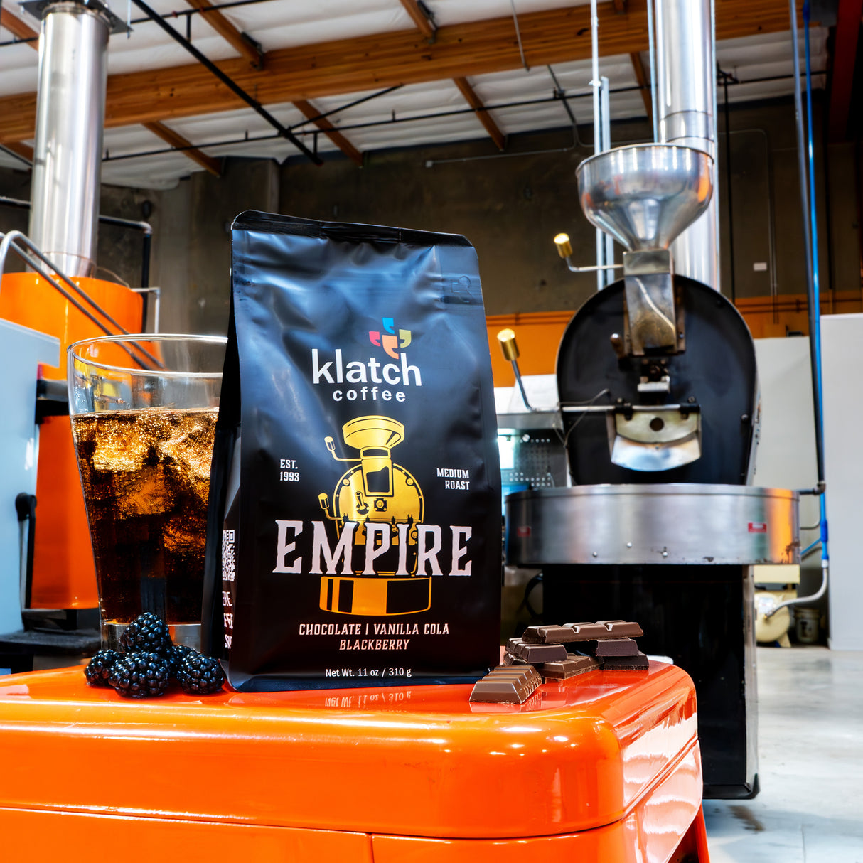 bag of empire coffee in front of coffee roaster