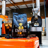 bag of empire coffee in front of coffee roaster